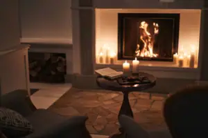 A table with candles and a book on it.