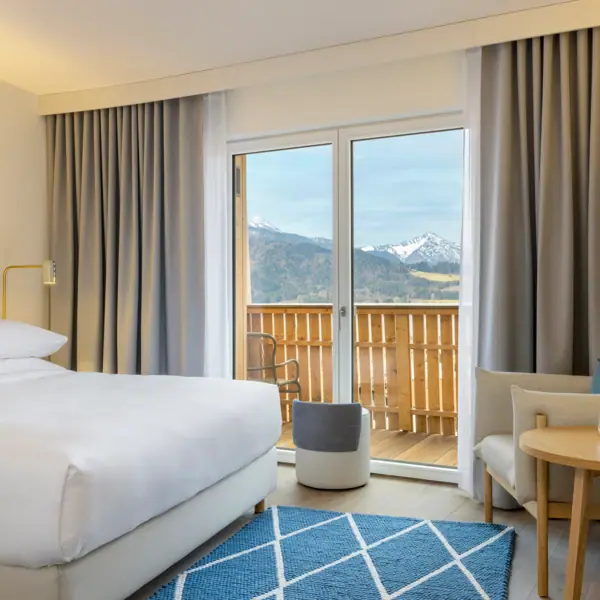 Hotel room with bed, carpet and armchair.