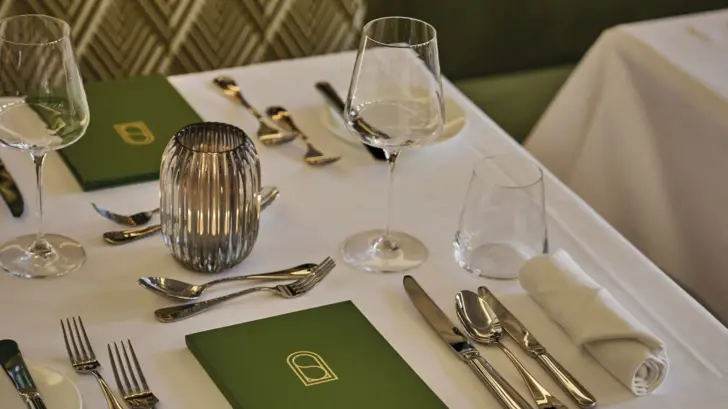 Win laid table with green menus at every seat.