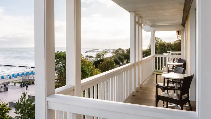 A terrace with chairs and tables overlooking a body of water.