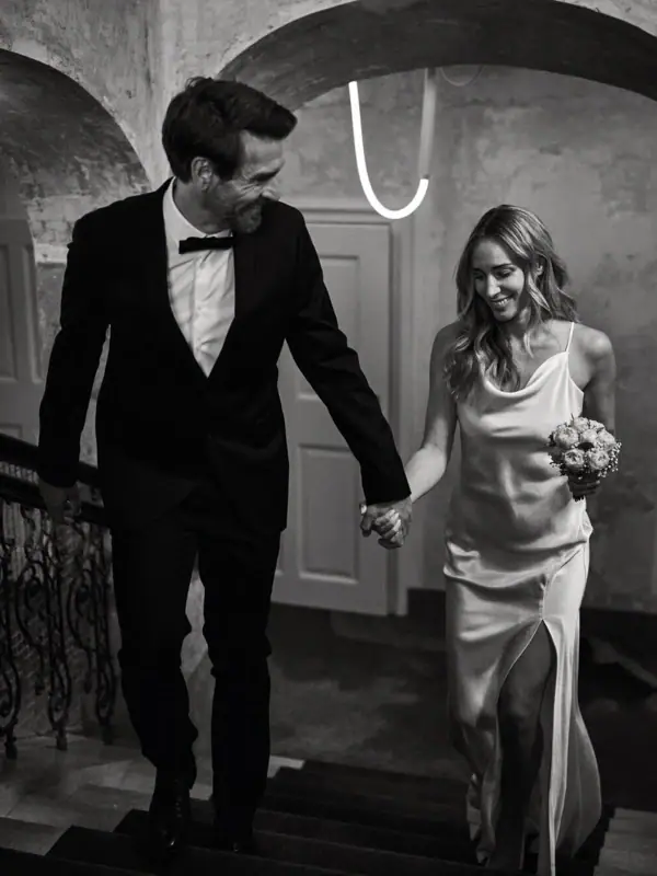 A man and woman holding hands and walking up stairs.