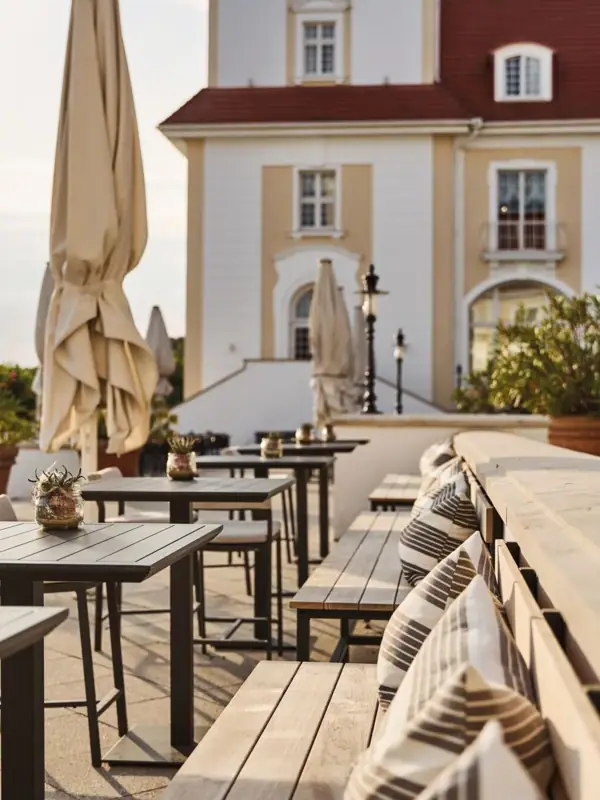 Outdoor tables and benches in front of a building.
