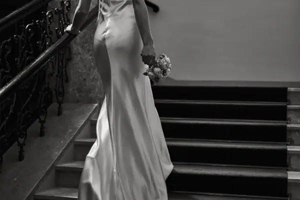 A woman in a white wedding dress holding a bouquet of flowers.