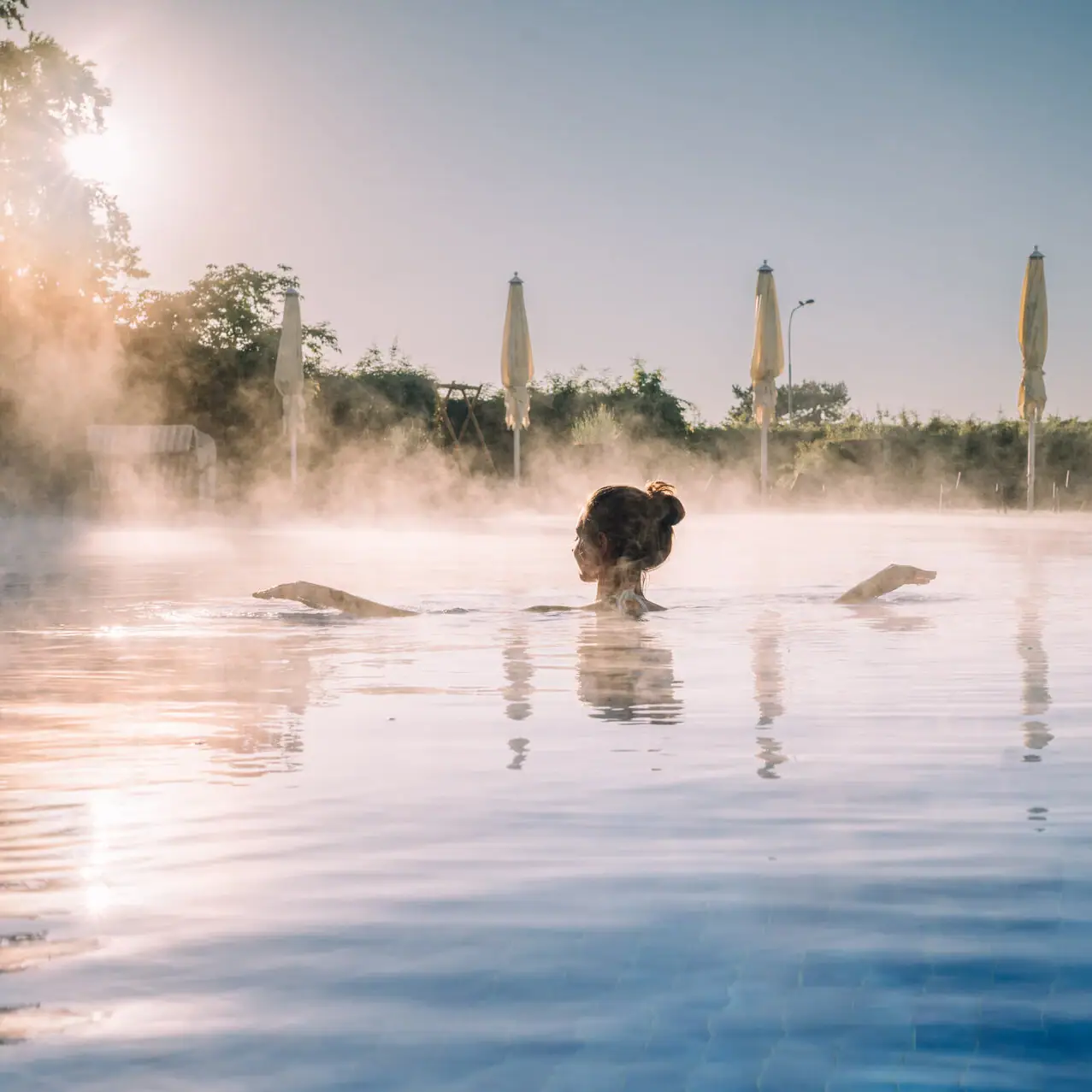 Eine Frau in einem Pool mit einer heißen Quelle.