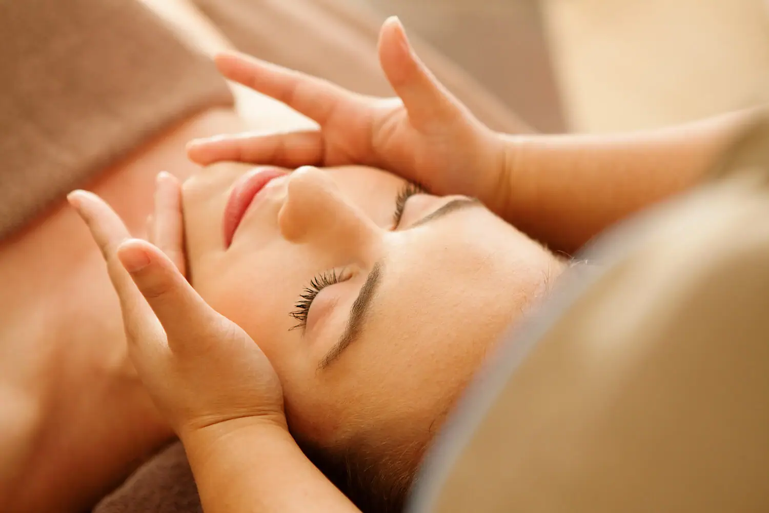 A woman lying down with her eyes closed, appearing relaxed and comfortable.