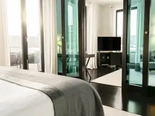 Bedroom with stained glass doors and a television.