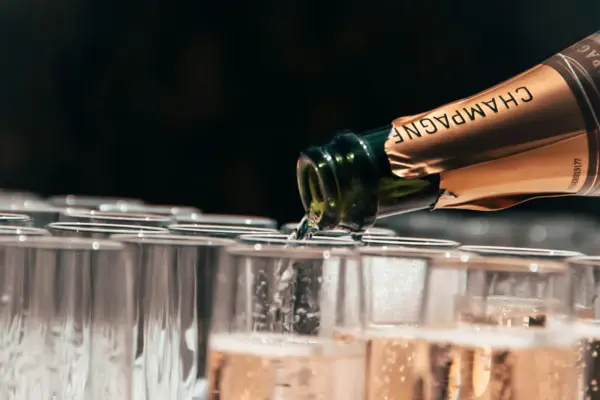 Champagne being poured into glasses from a bottle.