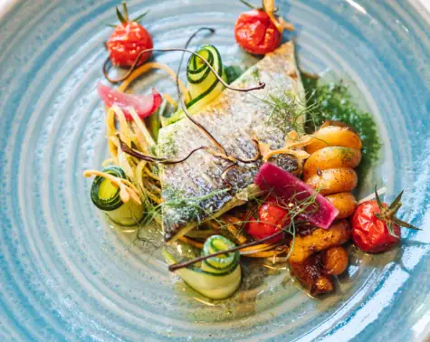 A beautifully arranged plate of food with vibrant fruits and garnishes.