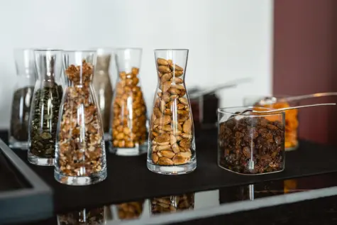 A variation of muesli and small yoghurt dishes with plates next to them. 