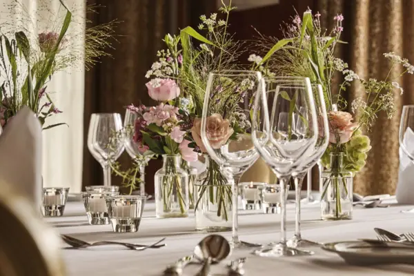 Elegantly laid table with flowers and candles as the centerpiece.