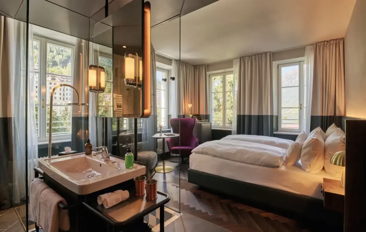 Elegant double room at the Straubinger Grand Hotel Bad Gastein with large windows, mountain views and stylish Art Deco-inspired furnishings.