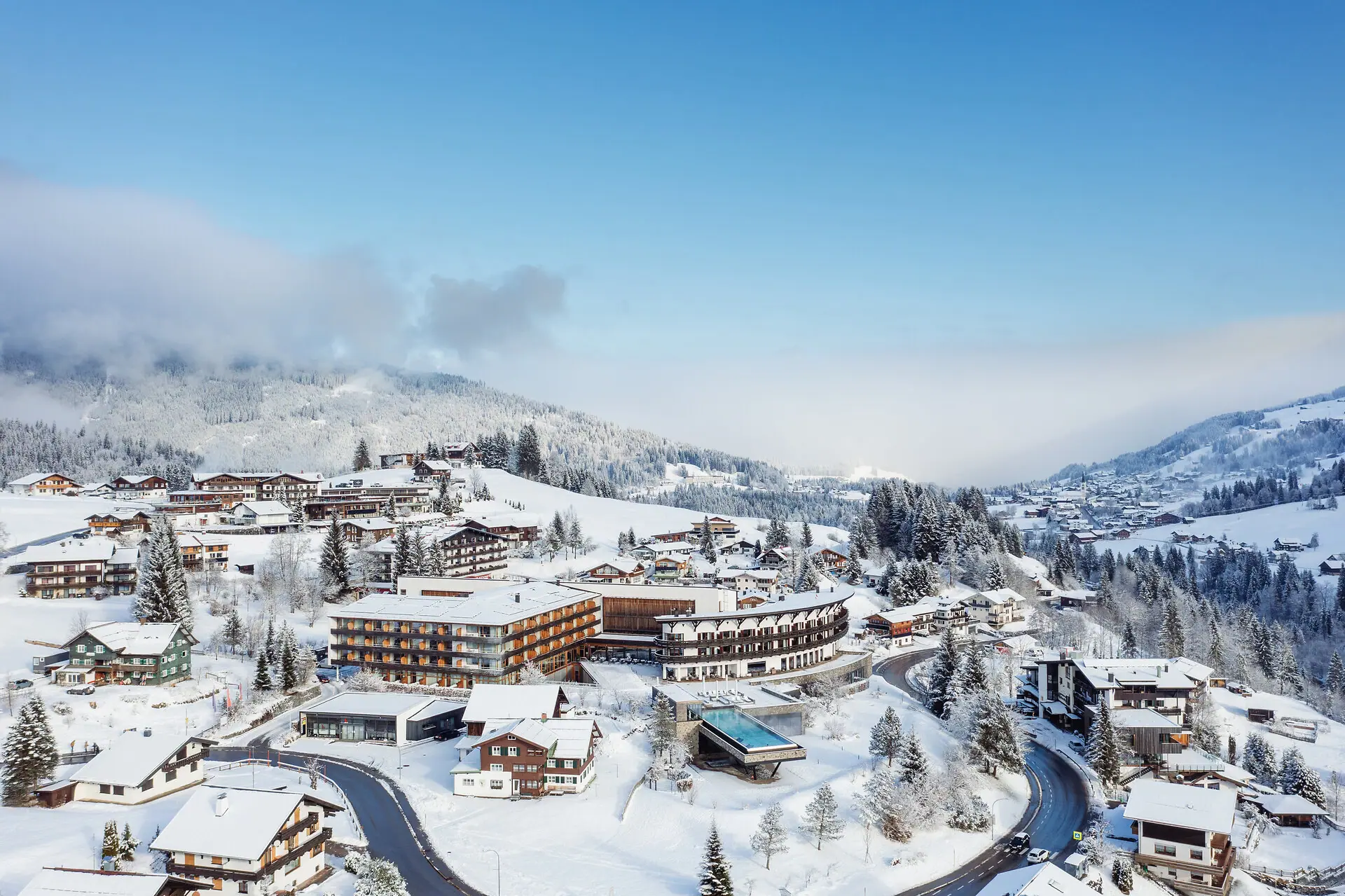 A snow-covered landscape with buildings and trees.
