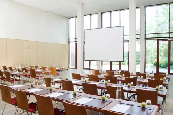 Tagungsloft Travemünde Ein moderner, lichtdurchfluteter Tagungsraum mit Tischen und Stühlen.