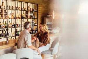 A man and a woman are sitting at a bar.