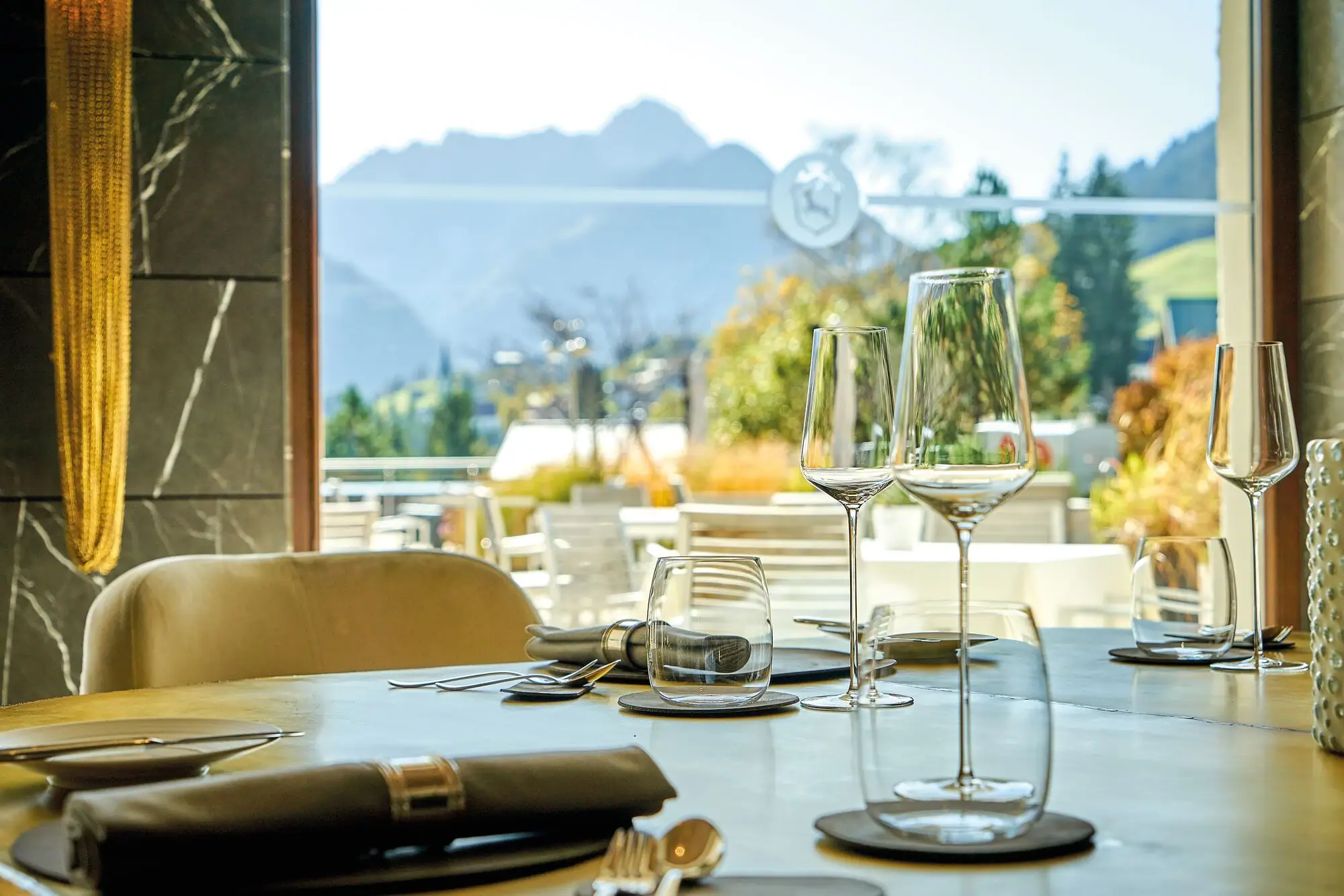 A table with wine glasses and cutlery.