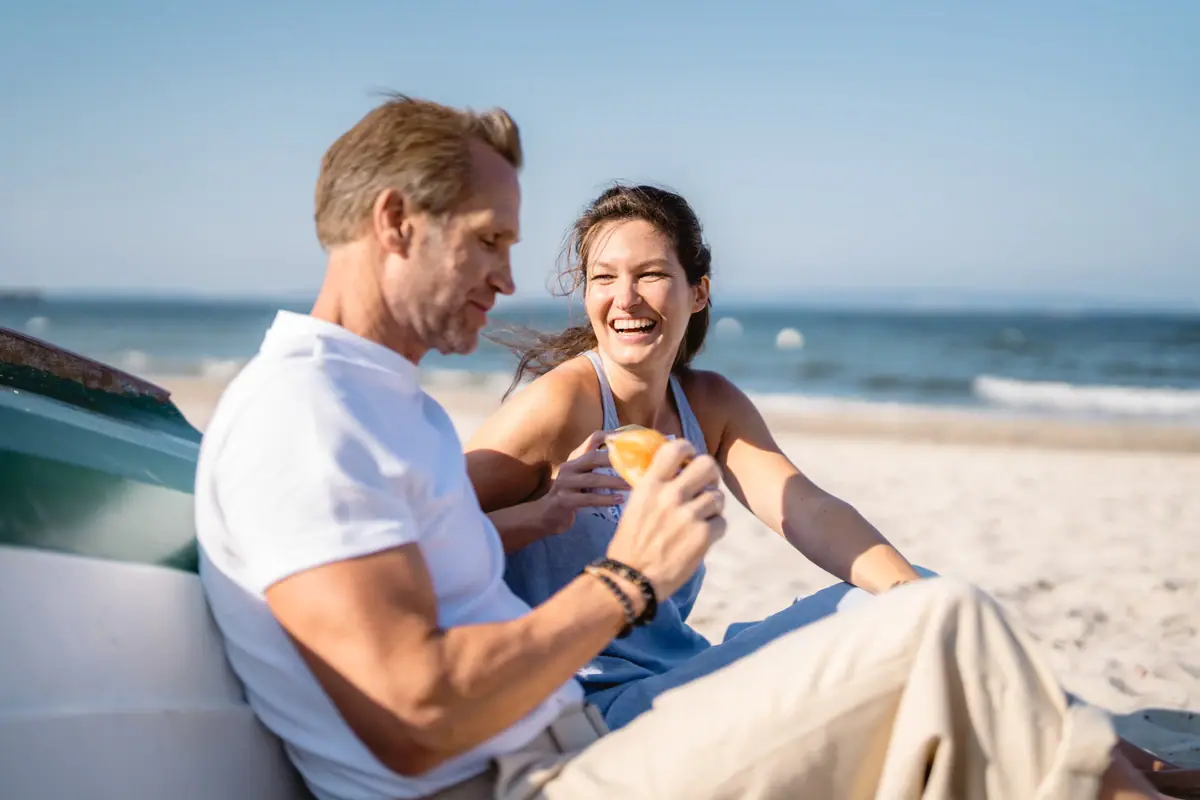 A man and a woman are sitting on the beach.