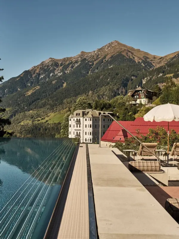 A swimming pool with a church in the background under a clear sky.
