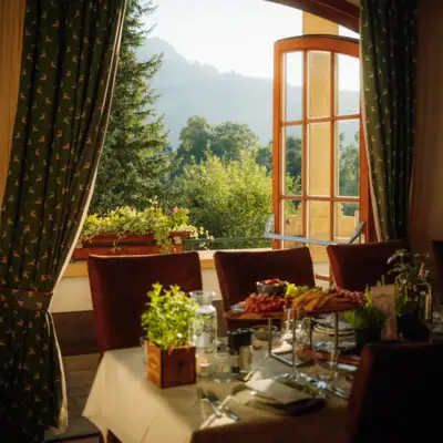 Ein Tisch mit Speisen darauf und ein Fenster mit Blick auf die Berge.