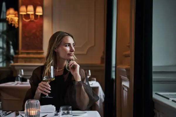 A woman holds a wine glass.