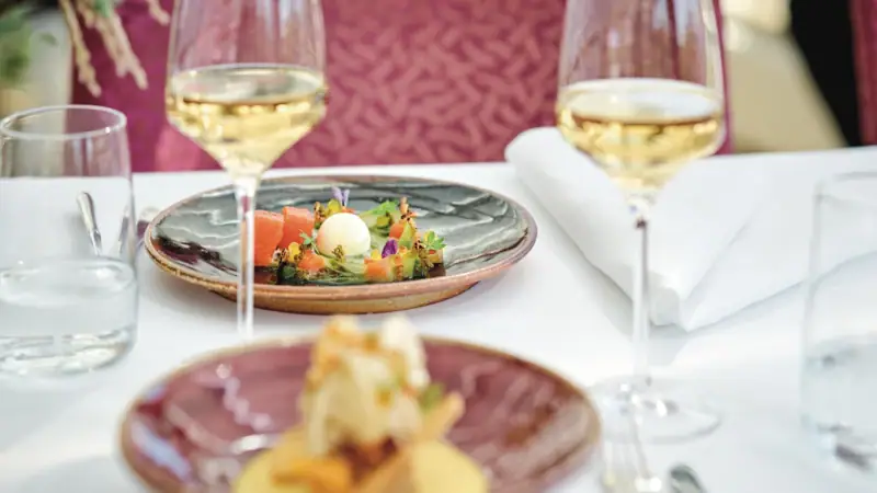 A plate of food on a table with wine glasses.