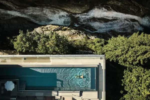 A person swimming in an outdoor pool.