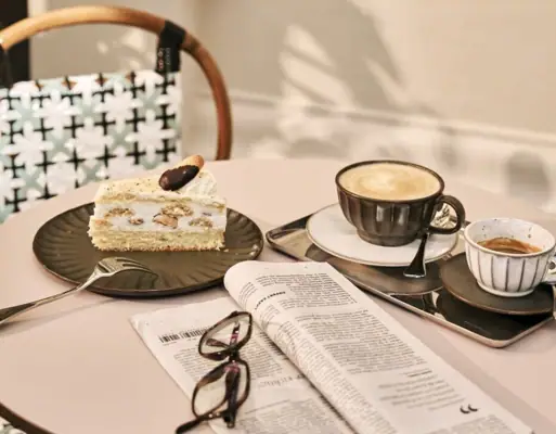 A table with a piece of cake and a coffee cup on it.