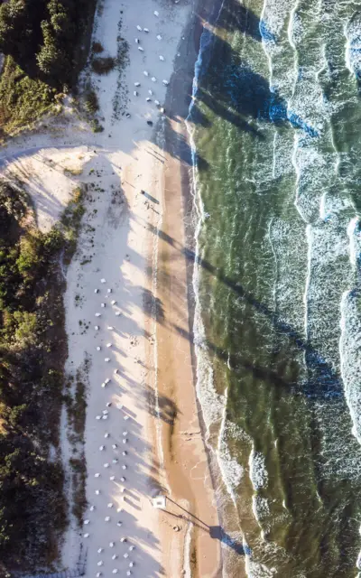 Bird's eye view of the beach with waves and sand