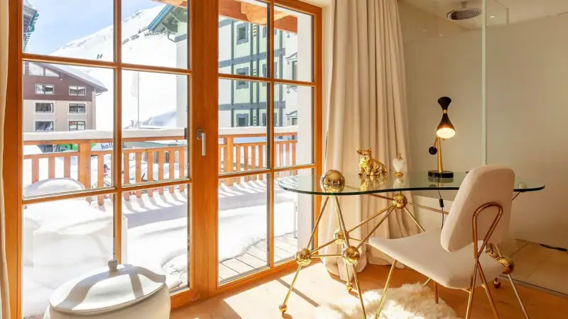 A room with a glass table and a chair.