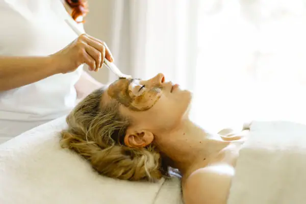 A woman receiving a facial mask indoors.