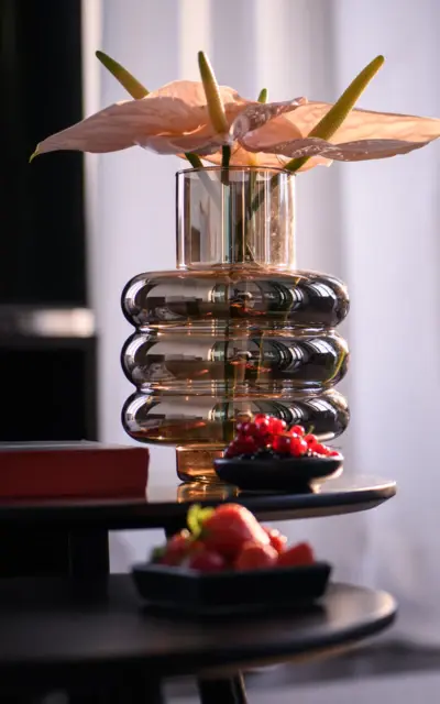 A vase with flowers on a coffee table in a well-furnished room.