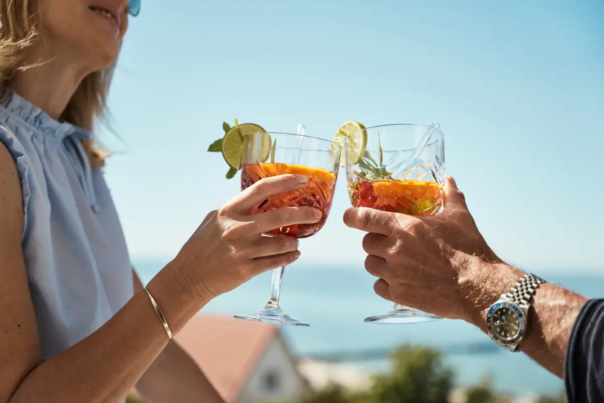 The hands of a couple holding glasses of drink
