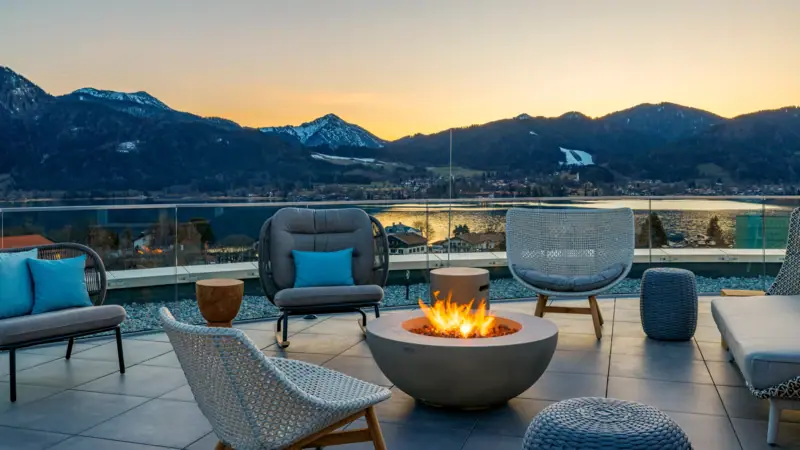 Fire pit with chairs and a view of mountains in the background.