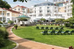 Deckchair in the garden with trees and a clear sky in the background.
