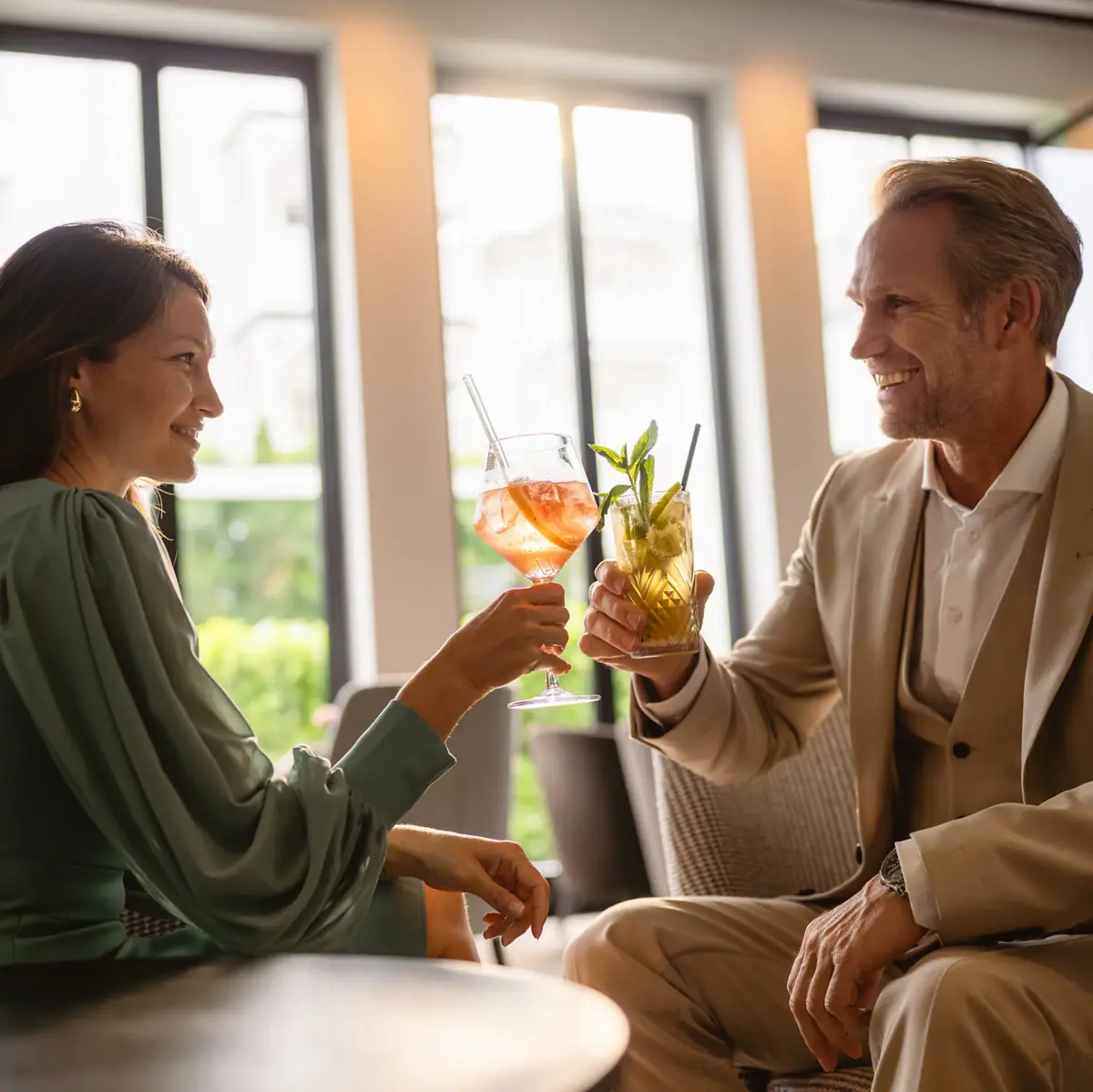 A man and a woman are holding drinks.