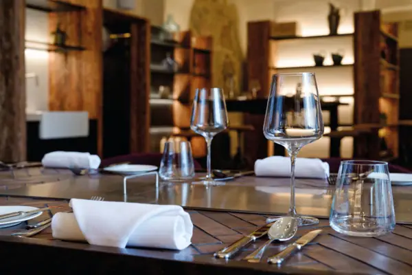 A table set with wine glasses and silverware.