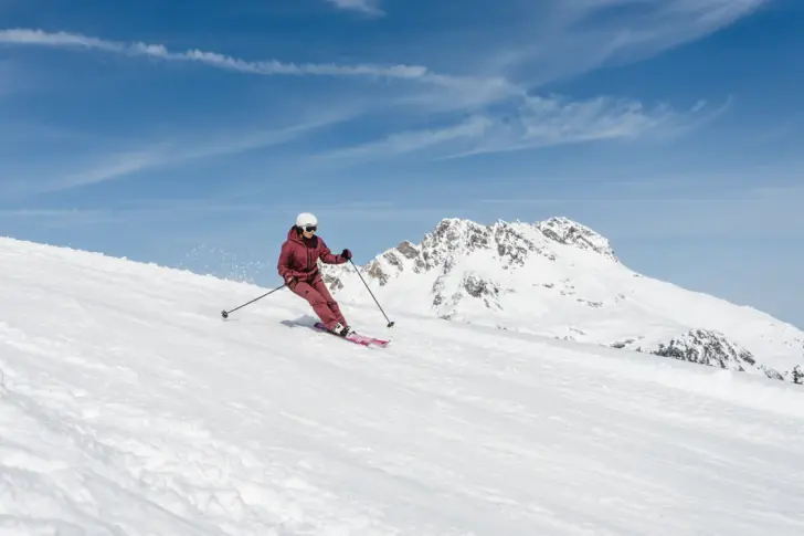 Person skiing on a snow-covered slope in a ski resort.