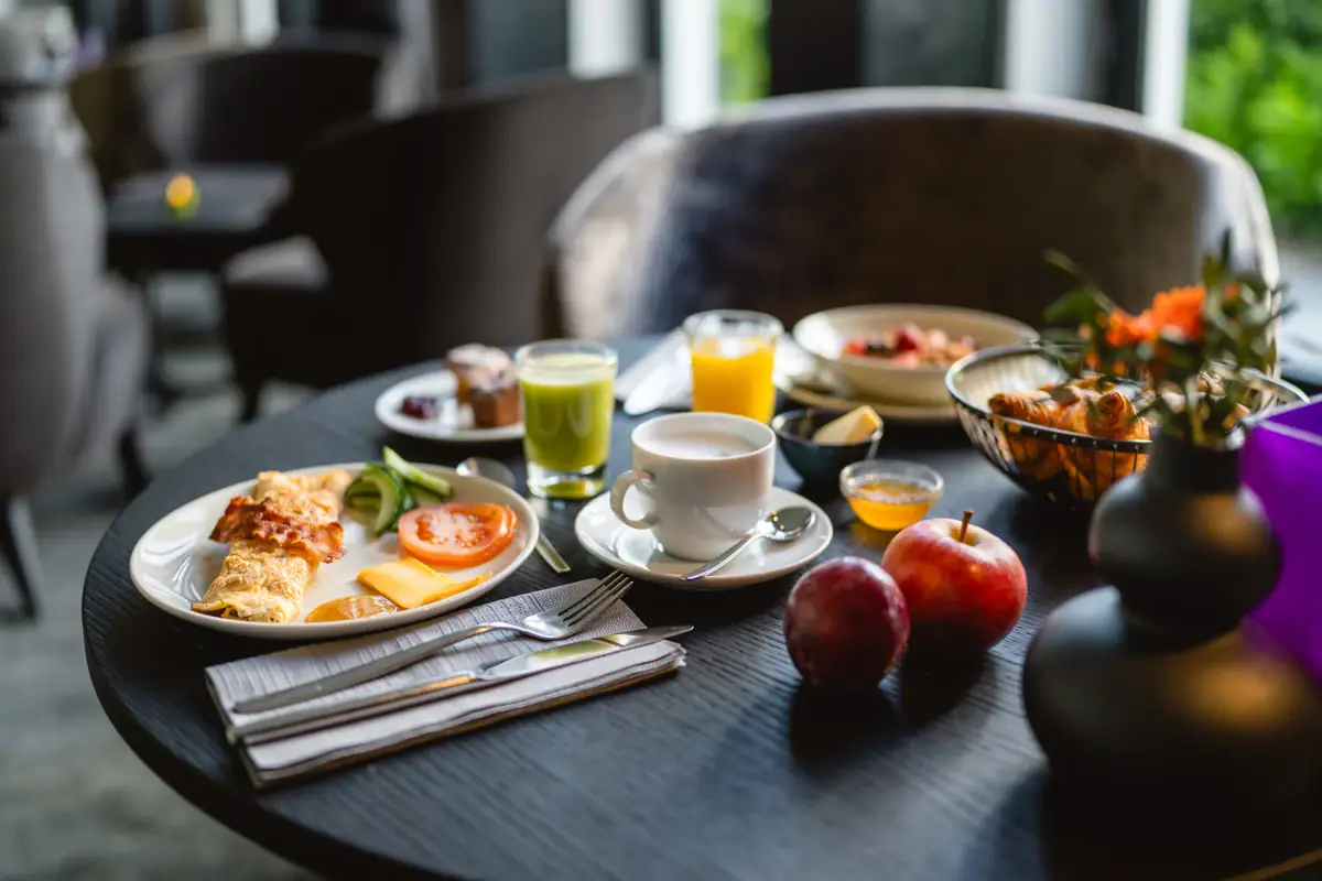 A table set with a variety of dishes and tableware, featuring a meal with plates, bowls, and a coffee cup.