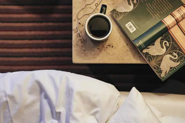 Coffee cup and book on a table indoors.