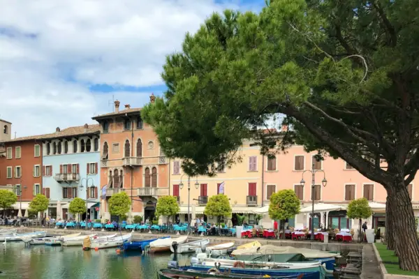 Desenzano del Garda A group of boats on the water next to some buildings.