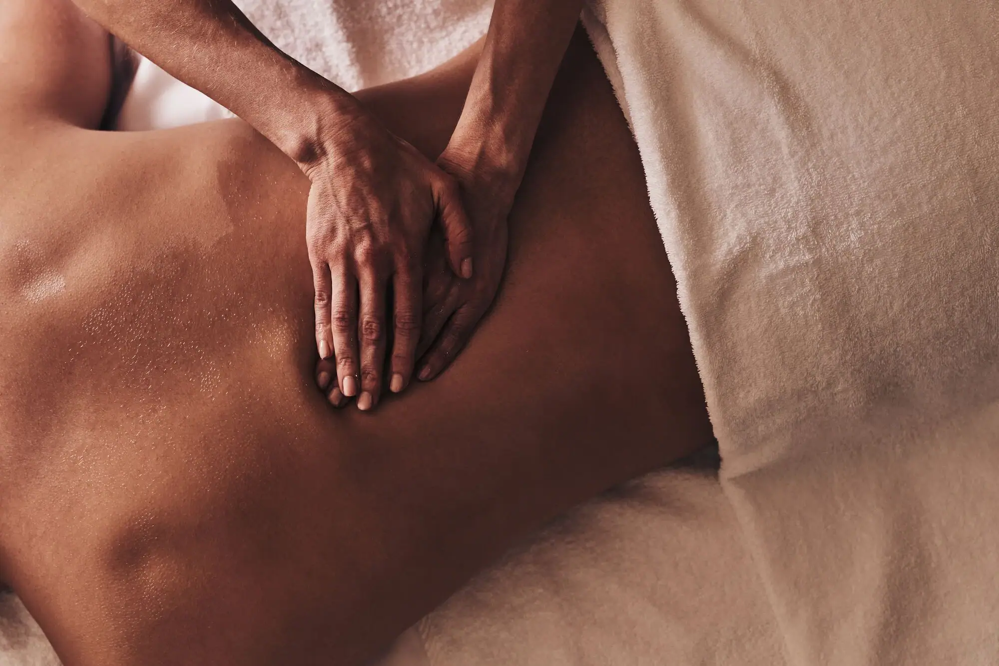 Person receiving a back massage indoors.