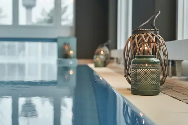 A pool with a candle holder and lit candles.