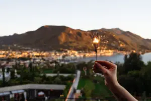 A person is holding a sparkler on New Year’s Eve at Lake Garda.