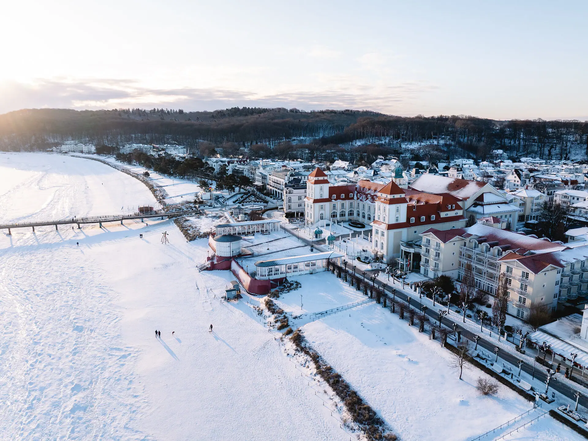 A snow-covered town with buildings and a bridge.