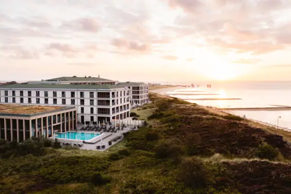 A building with a swimming pool by the water.