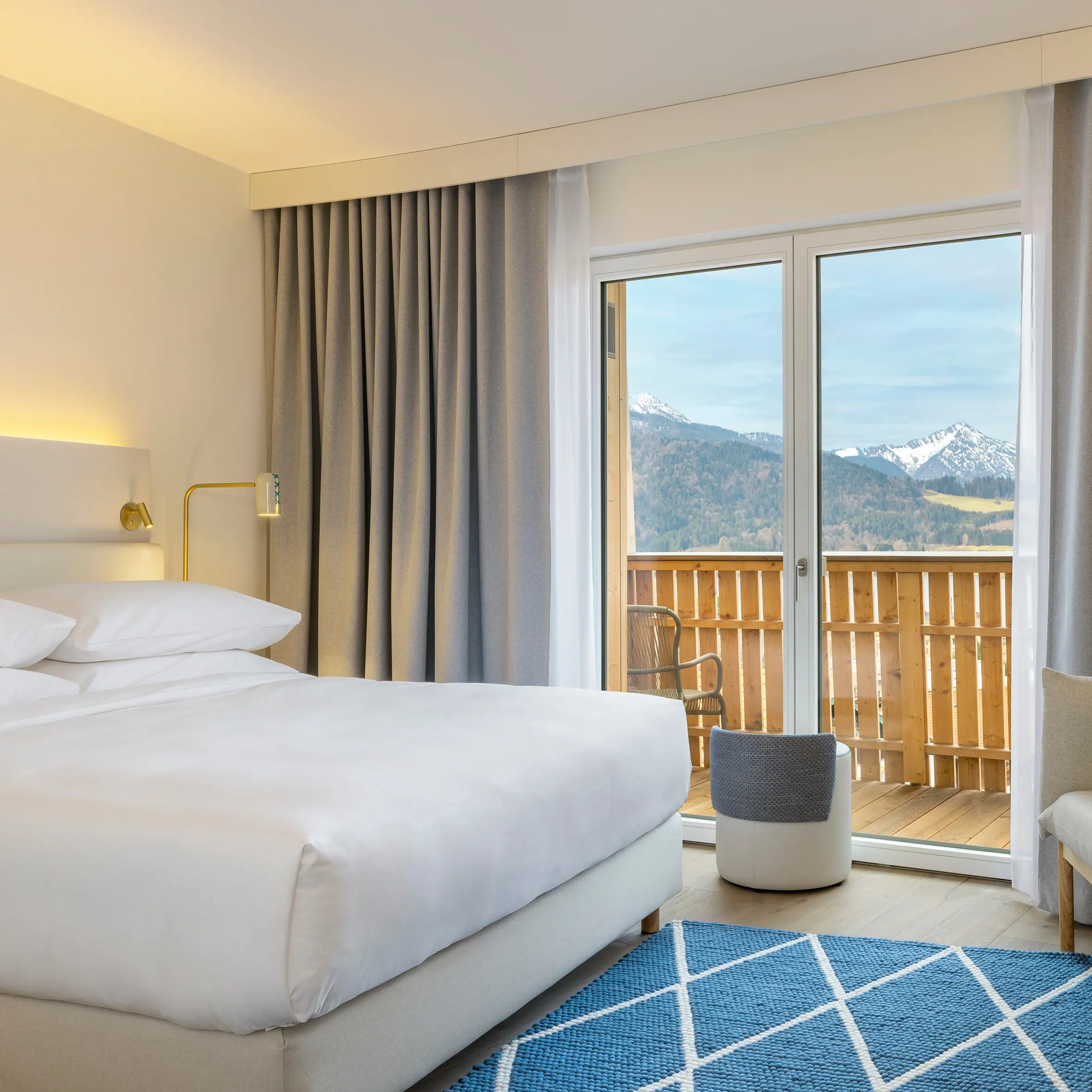 A room with a bed, a rug and a chair.