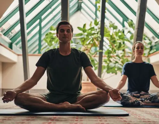 Paar meditiert im Yoga-Sitz 