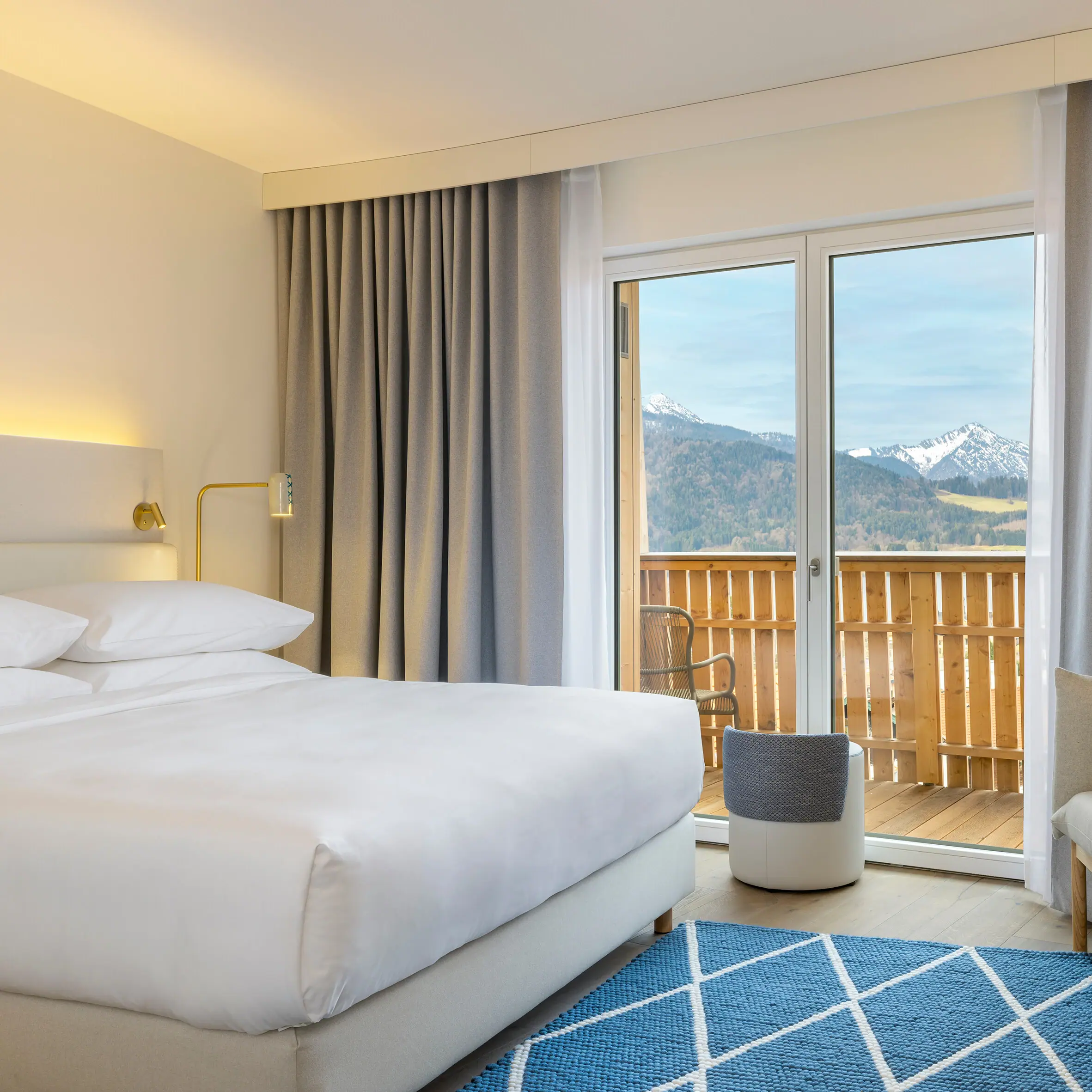 A hotel room with a bed, carpet and armchair