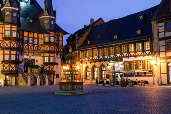 Building with a fountain in front of it at night.