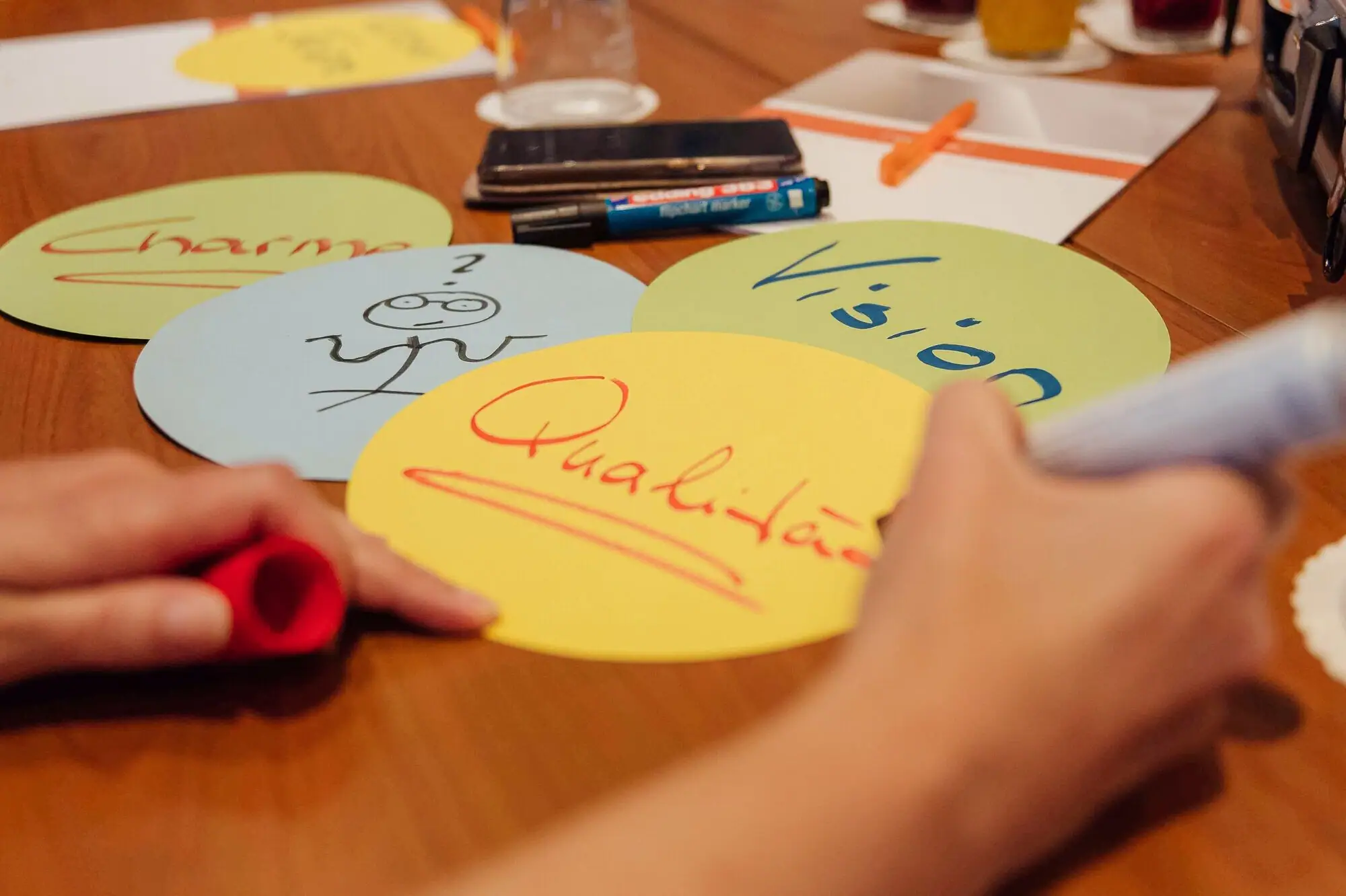 A person writing with a pen on a circular surface.