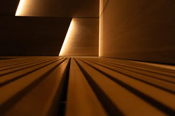 Wooden wall illuminated with light, showcasing symmetry and lines.
